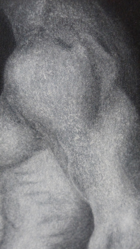 Chalk drawing of man's body on black paper shoulder close-up