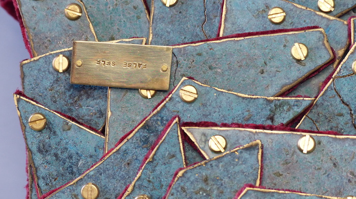 Layered brass patinated female torso name close-up