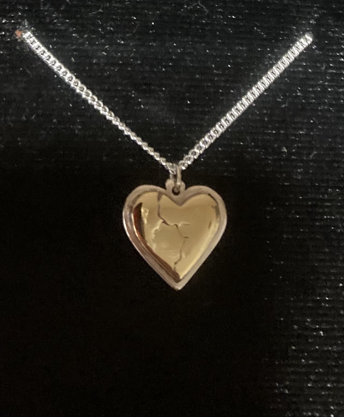 Broken Brass Heart on a Silver Heart Base with silver chain front side