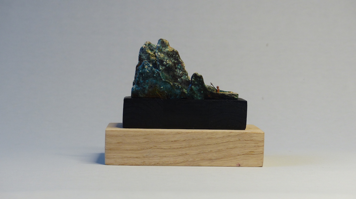 Green patinated brass mountain and fisherman ring sculpture back