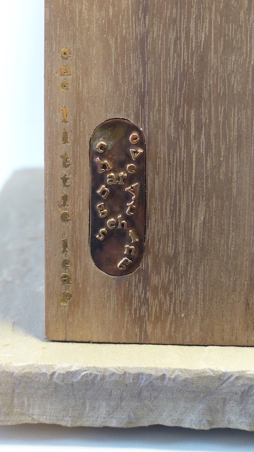 Cracked walnut block filled with brass cells name close-up