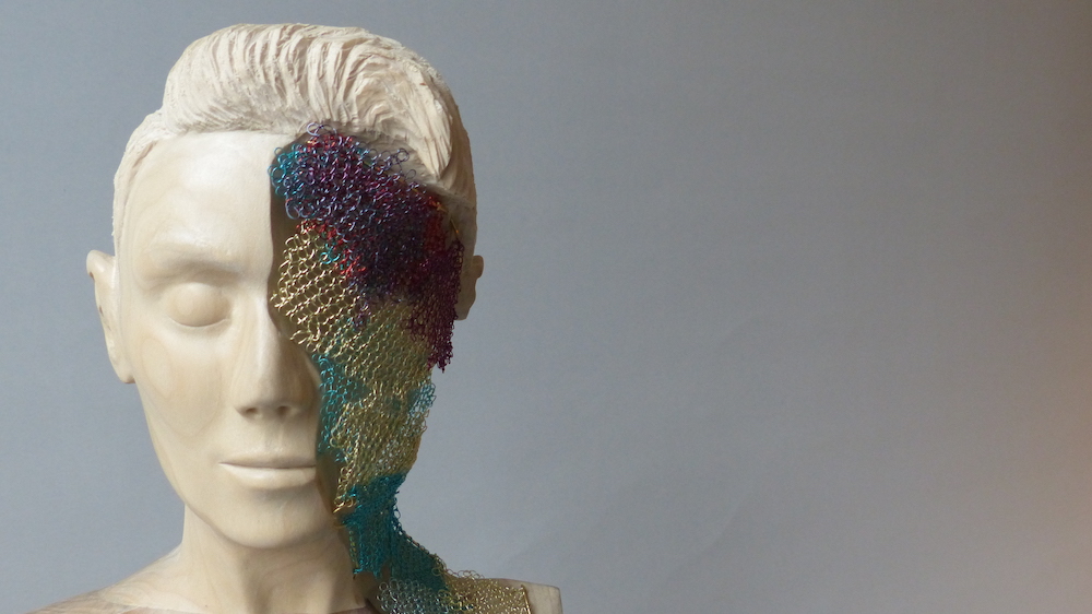 Cream hardwood female sculpture with colourful crochet layers head closeup